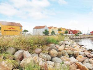 una pila de rocas junto a un río con casas en 6 person holiday home in Rudk bing en Rudkøbing