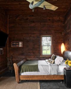 - une chambre avec un lit dans un mur en bois dans l'établissement The Eddie Hotel and Farm, à Bloomfield