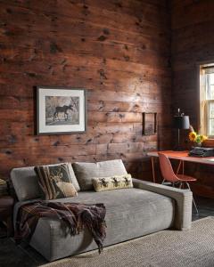 a living room with a couch and a desk at The Eddie Hotel and Farm in Bloomfield