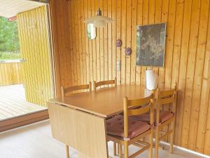 a dining room with a wooden table and chairs at 5 person holiday home in R dby in Rødby