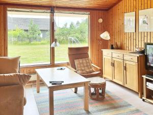 a living room with a table and a chair at 5 person holiday home in R dby in Rødby