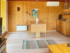 a kitchen with wooden walls and a table and a rug at 5 person holiday home in R dby in Rødby