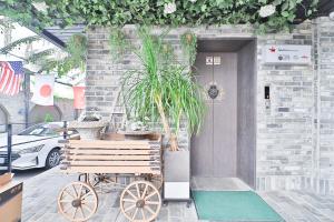 a wooden cart with plants on it in front of a door at Daegu February Hotel Hwanggeum in Daegu