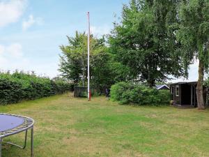 een tuin met een tafel en een paal in het gras bij 4 person holiday home in Alling bro in Allingåbro