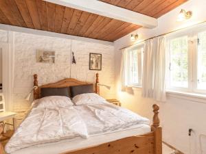 1 dormitorio con 1 cama con cabecero de madera y 2 ventanas en Holiday home Bagenkop III, en Bagenkop