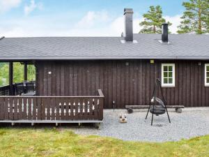 Casa de madera con valla y columpio en Holiday home Passebekk en Omholt
