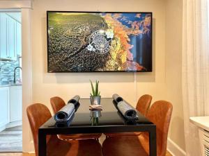 a dining room table with chairs and a painting on the wall at Immaculate, Newly Renovated 1 Bedroom Apt Near NYC in Hawthorne