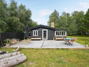 um camarote com um pátio com uma mesa e cadeiras em Holiday home Sjællands Odde XIX em Yderby