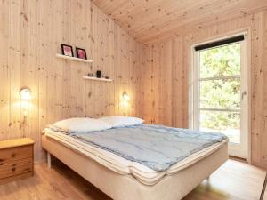 una camera con un letto su una parete in legno di Three-Bedroom Holiday home in Ålbæk 21 ad Ålbæk