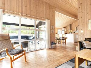 ÅlbækにあるThree-Bedroom Holiday home in Ålbæk 21の木製の壁と大きな窓のあるリビングルーム