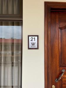 Un cartello su un muro accanto a una porta di Hotel Wilson Condega a Liberia