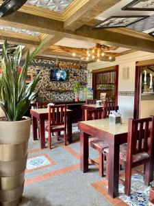 um restaurante com mesas e cadeiras de madeira e um vaso de plantas em Hotel Wilson Condega em Liberia