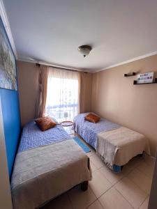 a room with two beds and a window at Apart Mejillones - Dpto 24 in Mejillones