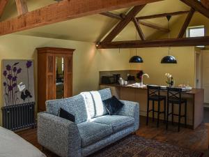 a living room with a couch and a kitchen at The Byre in Helmsley