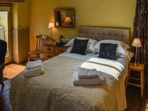 a bedroom with a large bed with towels on it at The Byre in Helmsley