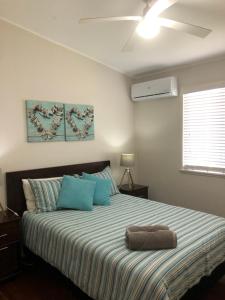 a bedroom with a large bed with blue pillows at Redland BayBreeze in Redland Bay