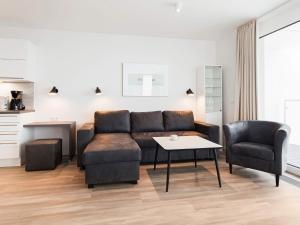 een woonkamer met een bank en een tafel en stoelen bij Apartment Wendtorf III in Wendtorf