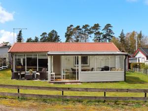 una pequeña casa con techo naranja en un patio en 5 person holiday home in MELLBYSTRAND en Mellbystrand