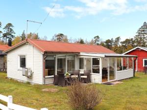 una pequeña casa blanca con techo rojo en 5 person holiday home in MELLBYSTRAND en Mellbystrand