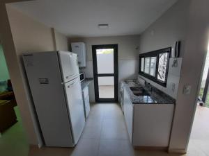 a kitchen with a refrigerator and a sink in it at COMPLEJO CRUZ in Alta Gracia