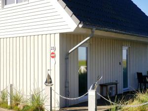 a white building with a door and a chain around it at 4 person holiday home in Wendtorf in Wendtorf