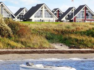 a boat sitting on the beach in front of some houses at 4 person holiday home in Wendtorf in Wendtorf
