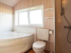 a bathroom with a tub and a toilet and a sink at Three-Bedroom Holiday home in Grömitz 4 in Grömitz