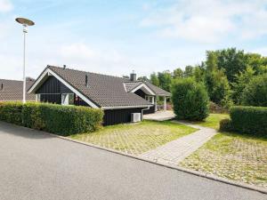 a house with a black roof and a driveway at Three-Bedroom Holiday home in Grömitz 4 in Grömitz