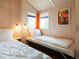グレーミッツにあるThree-Bedroom Holiday home in Grömitz 4のベッド2台と窓が備わる小さな客室です。
