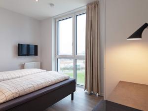 ein Schlafzimmer mit einem Bett und einem großen Fenster in der Unterkunft 6 Personen Ferienhaus in Wendtorf in Wendtorf