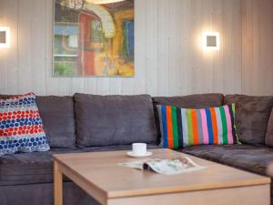 Sofá marrón con almohadas coloridas y mesa de centro en 6 person holiday home in GROEMITZ, en Grömitz
