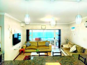 een woonkamer met een bank en een tafel bij Beachside 3 bed apartment with stunning seaviews in Amanzimtoti