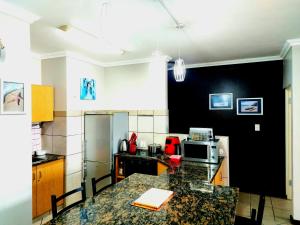a kitchen with a granite counter top in a kitchen at Beachside 3 bed apartment with stunning seaviews in Amanzimtoti