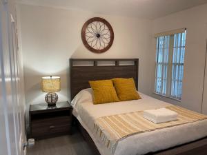 Un dormitorio con una cama y un reloj en la pared. en Fabulous Apartment 8 pax close Disney, en Kissimmee