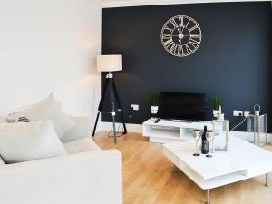 sala de estar con sofá blanco y reloj en la pared en Blueberry Hill en Beauly