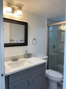Un baño con lavabo, inodoro y espejo. en Fabulous Apartment 8 pax close Disney, en Kissimmee 19 fotos más