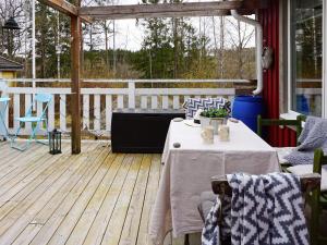 een houten terras met een tafel en een bank bij 5 person holiday home in FLEN in Flen