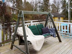 a swing on a deck with two chairs at 5 person holiday home in FLEN in Flen