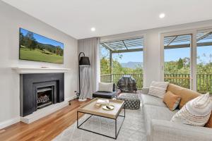 un soggiorno con divano e camino di Premium Villa 2br Malvasia at Cypress Lakes - Modernised Comfort a Pokolbin