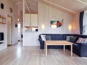 a living room with a blue couch and a table at Two-Bedroom Holiday home in Grömitz 1 in Grömitz