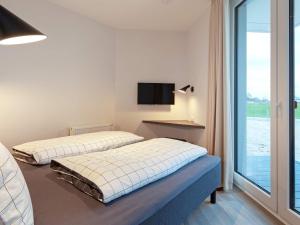twee bedden in een kamer met een tv aan de muur bij Apartment Wendtorf IV in Wendtorf