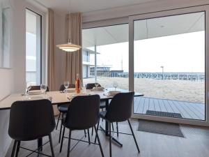 een eetkamer met een tafel en stoelen en een groot raam bij Apartment Wendtorf IV in Wendtorf