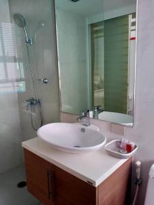 W łazience znajduje się biała umywalka i lustro. w obiekcie Light, airy, east facing 2 bed/2 bath pool views w mieście Hua Hin