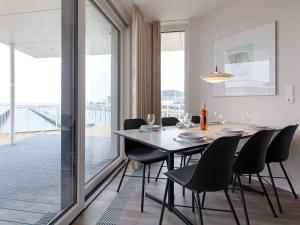 ein Esszimmer mit einem Tisch und Stühlen sowie einem großen Fenster in der Unterkunft Apartment Wendtorf X in Wendtorf