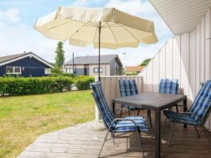 una mesa y sillas con una sombrilla en el patio en Two-Bedroom Holiday home in Grömitz 2, en Grömitz
