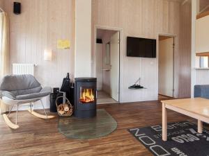 ein Wohnzimmer mit einem Kamin und einem Stuhl in der Unterkunft Two-Bedroom Holiday home in Grömitz 2 in Grömitz