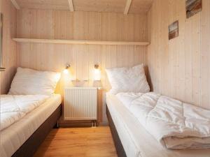 2 Einzelbetten in einem Zimmer mit einem Heizkörper in der Unterkunft 6 person holiday home in GROEMITZ in Grömitz