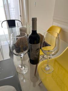 una bottiglia di vino e due bicchieri di vino su un tavolo di Departamento en pleno centro en complejo con Pileta y Gimnasio a Córdoba