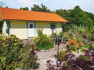 une maison avec un toit orange et un jardin dans l'établissement Holiday home BRASTAD XIII, à Brastad