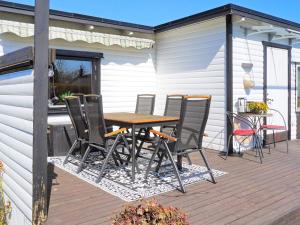 Un patio con una mesa y sillas en una terraza. en 6 person holiday home in SÖLVESBORG, en Sölvesborg 13 fotos más